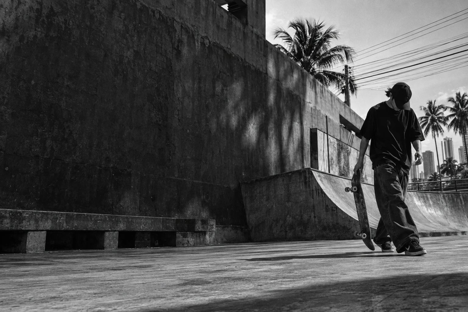 Black and white concept photograph of a skateboarder beside a concrete ramp